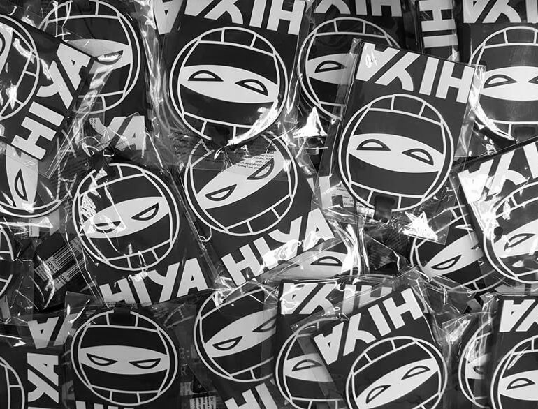 hiya-volleyball-tags Photo of a bunch of bagged luggage tags that are the icon of volleyball combined with ninja eyes and HIYA text underneath