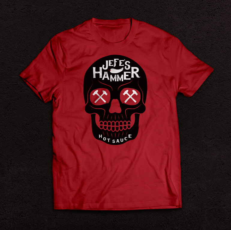 jefes-hammer-tshirtB Red t-shirt with black skull and white text printed on it, sitting on a black background